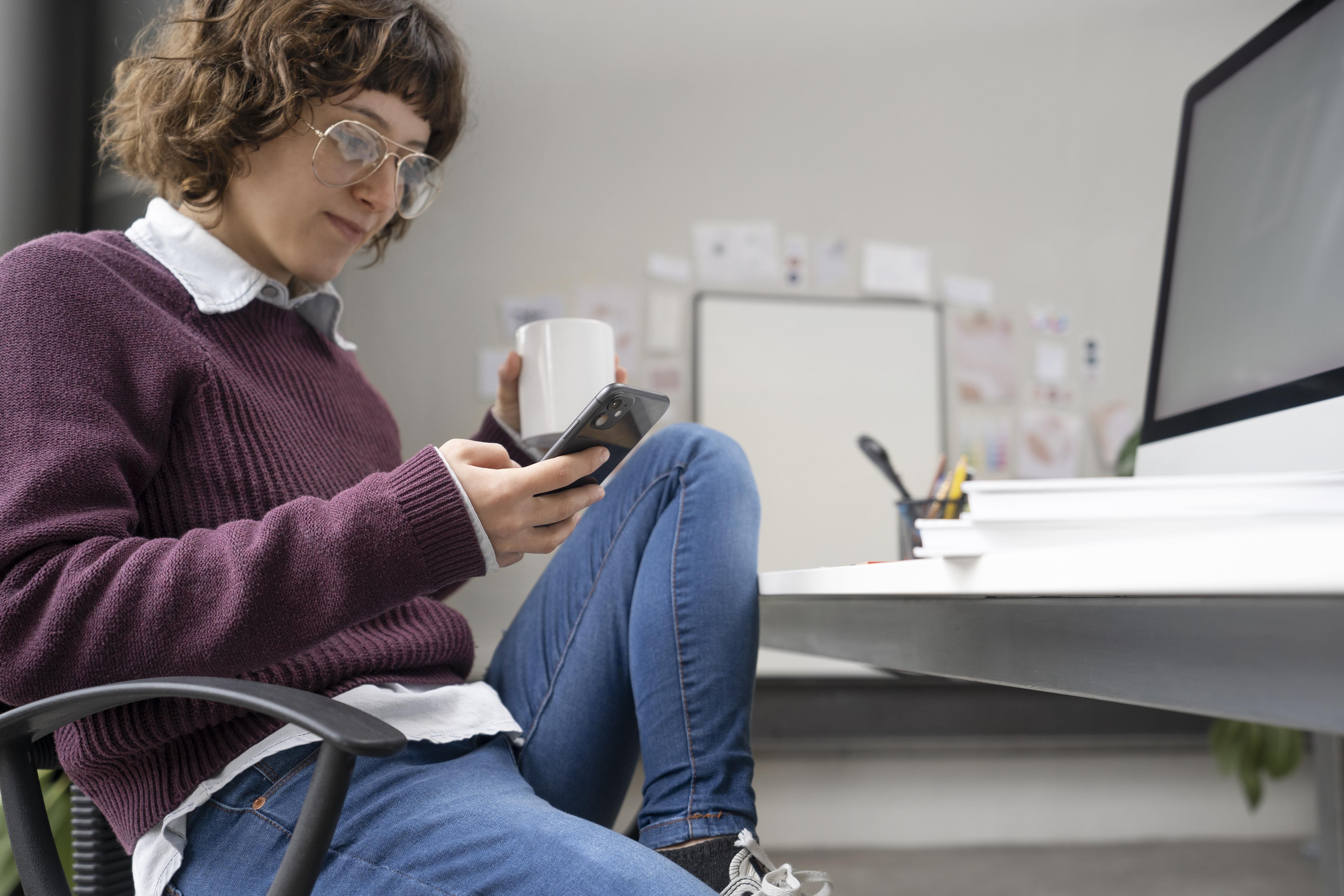 Young Female Designer Checking Her Smartphone