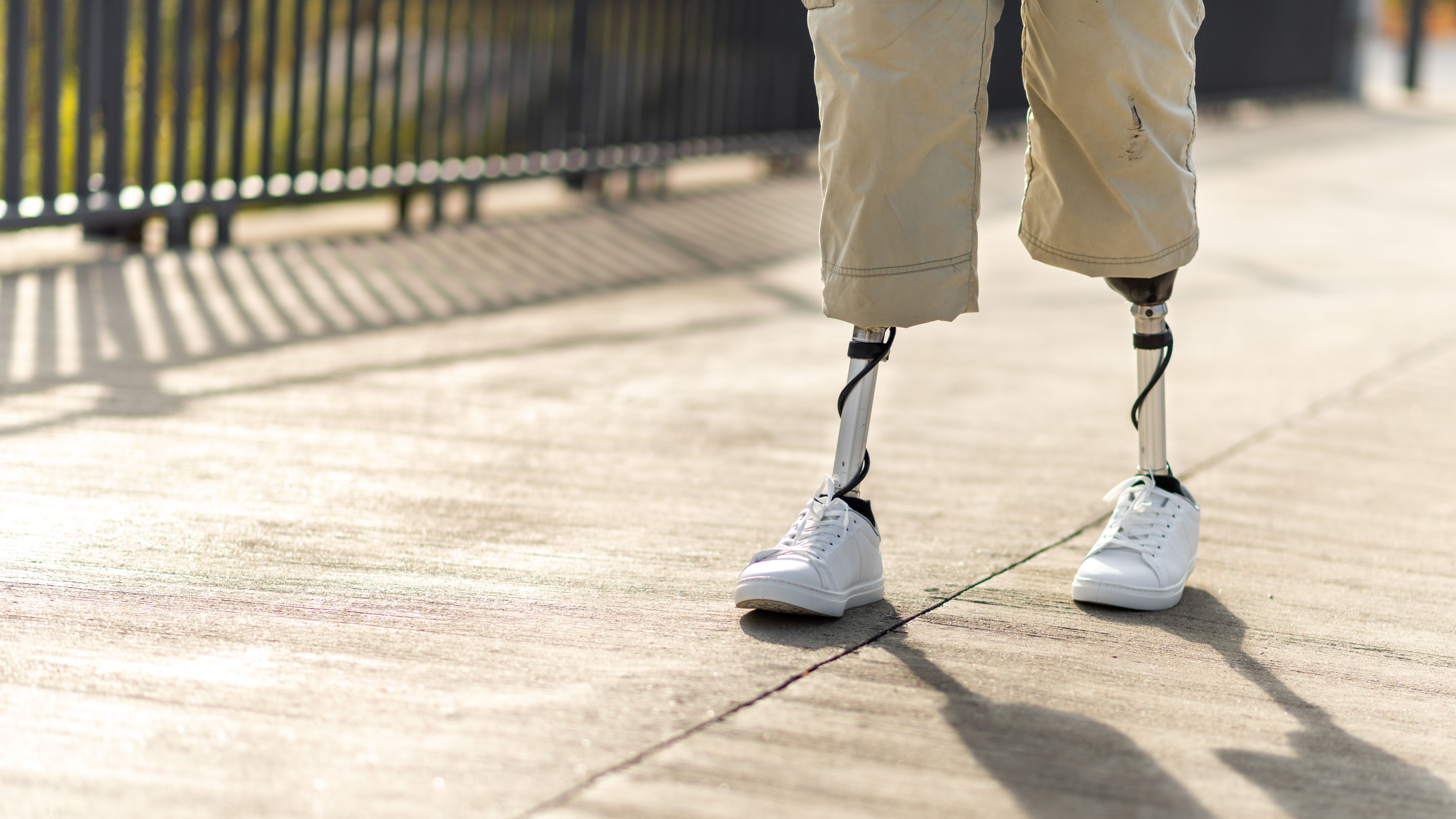 View Walking Man With Prosthetic Legs White Sneakers